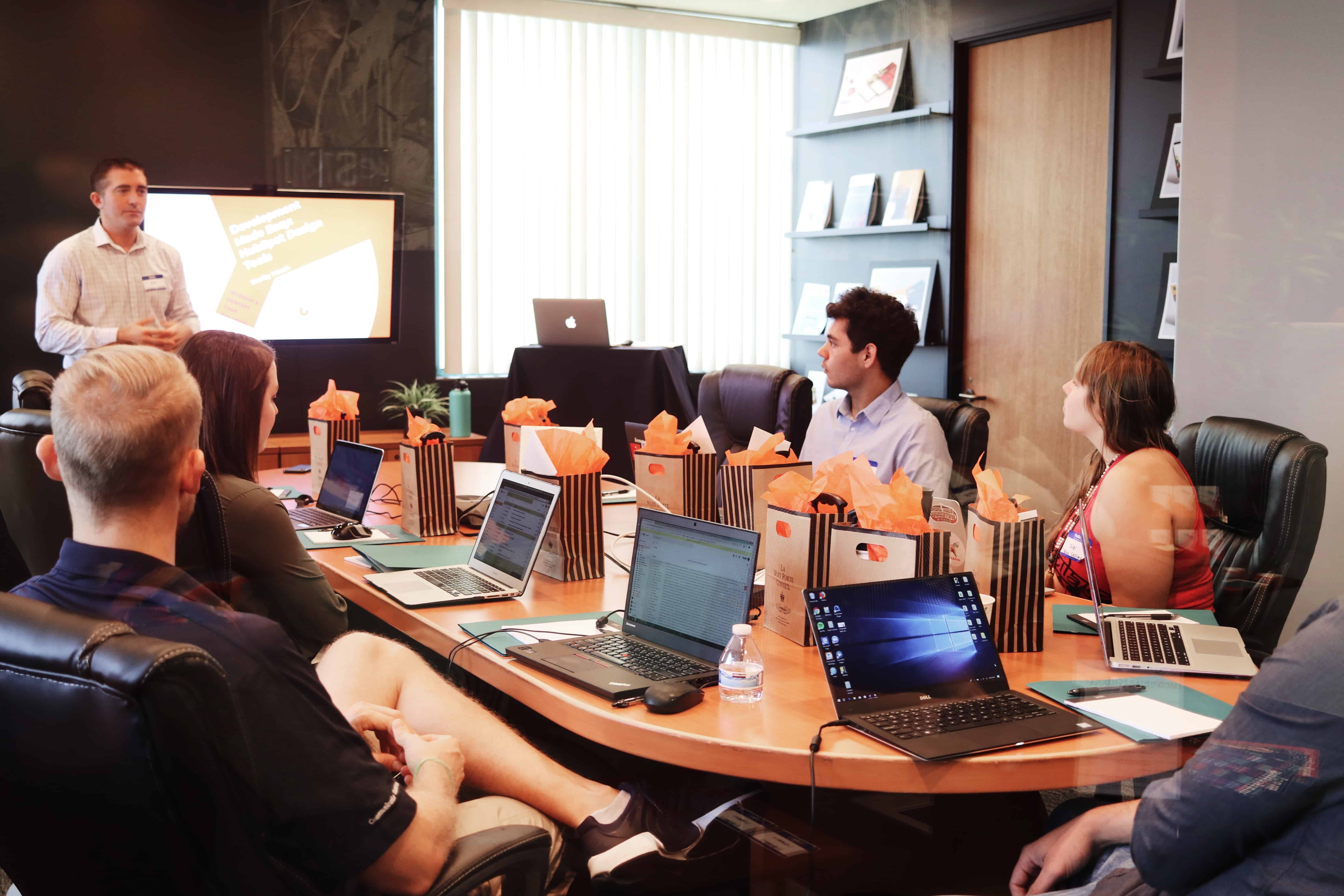 Reunión del equipo de ventas con un miembro explicando algo al resto